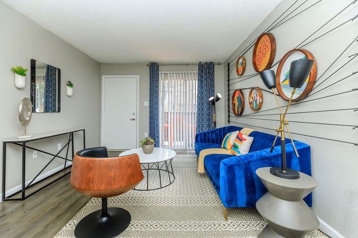 a living room with blue furniture and a blue couch at The Orbit Apartments