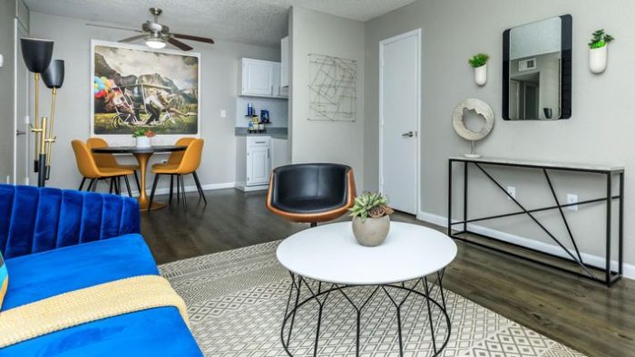 a living room with blue and yellow furniture at The Orbit Apartments